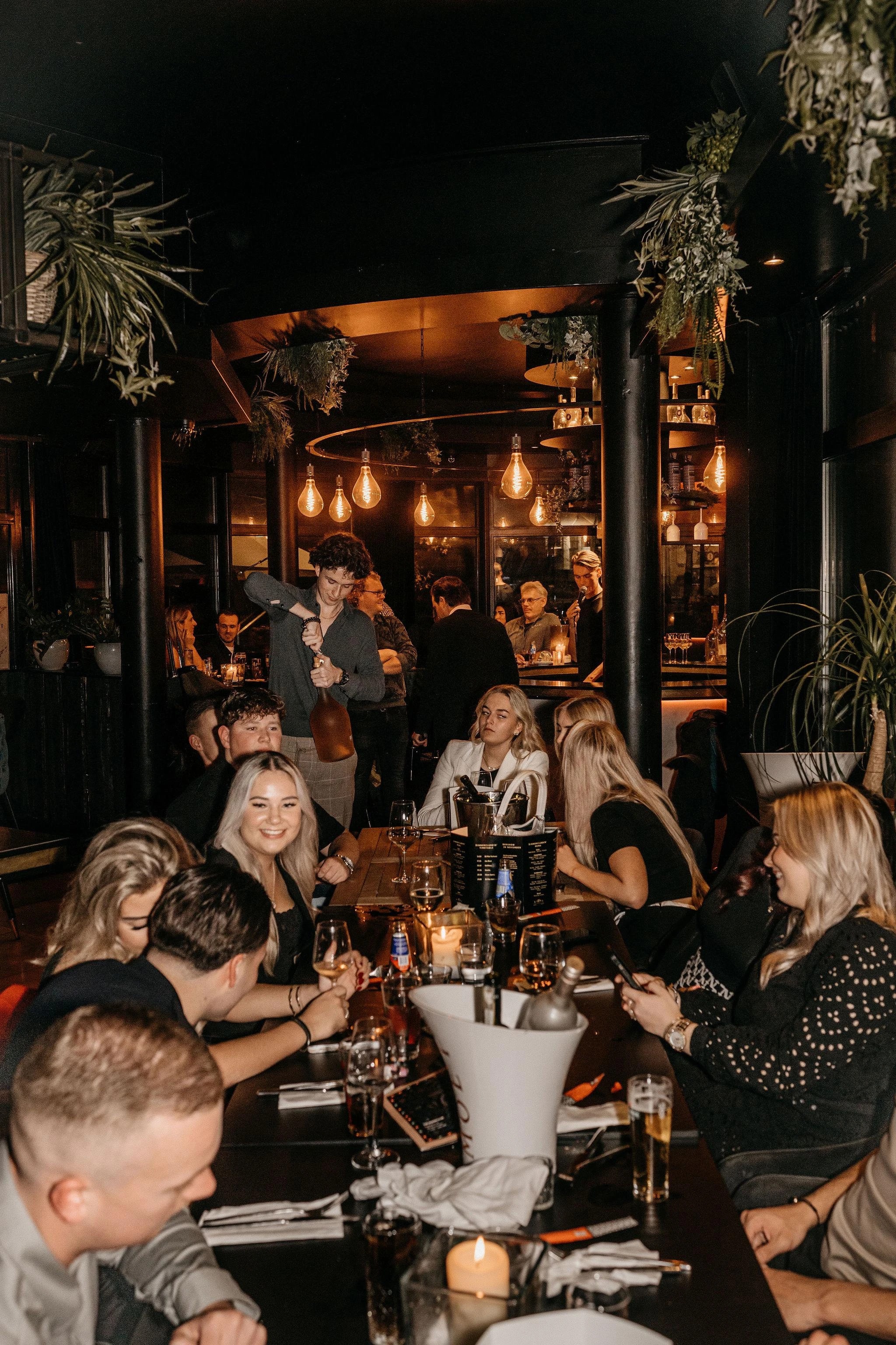 Gasten aan tafel in het restaurant van The Dinnerclub